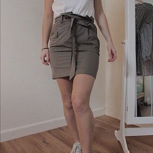 Short green skirt with a belt